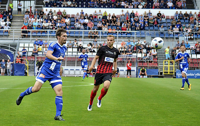 Aleš Škerle odehrává míč před útočníkem Opavy Kuzmanovičem.