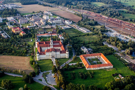 Klášterní Hradisko a skoro stejně velká budova někdejších stájí v popředí. Možná by z nich mohl být luxusní hotel, avšak dnes v nich funguje například záchytka.