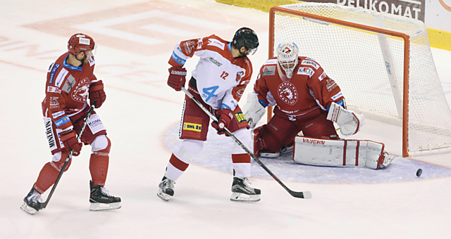 Jan Knotek zkouší tečovat před brankářem Třince Šimonem Hrubcem, který zatím ovládá brankářské statistiky extraligy.