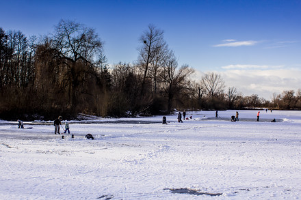Nadšenci čistí zamrzlou hladinu od sněhu a připravují hřiště, kde si mohou zahrát třeba hokej.