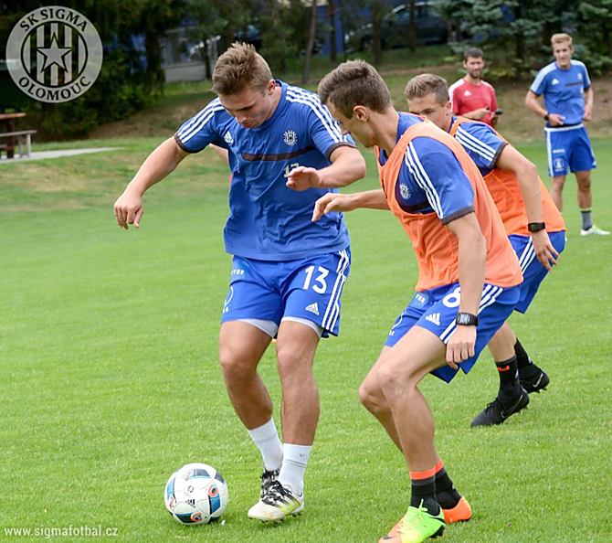 Zdeněk Linhart si na tréninku ve Slatinicích snaží pokrýt míč před Šimonem Faltou.