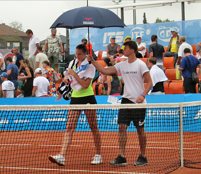 Kristýna Plíšková při odchodu do zázemí turnaje při dešti, který duel přerušil na hodinu a půl.