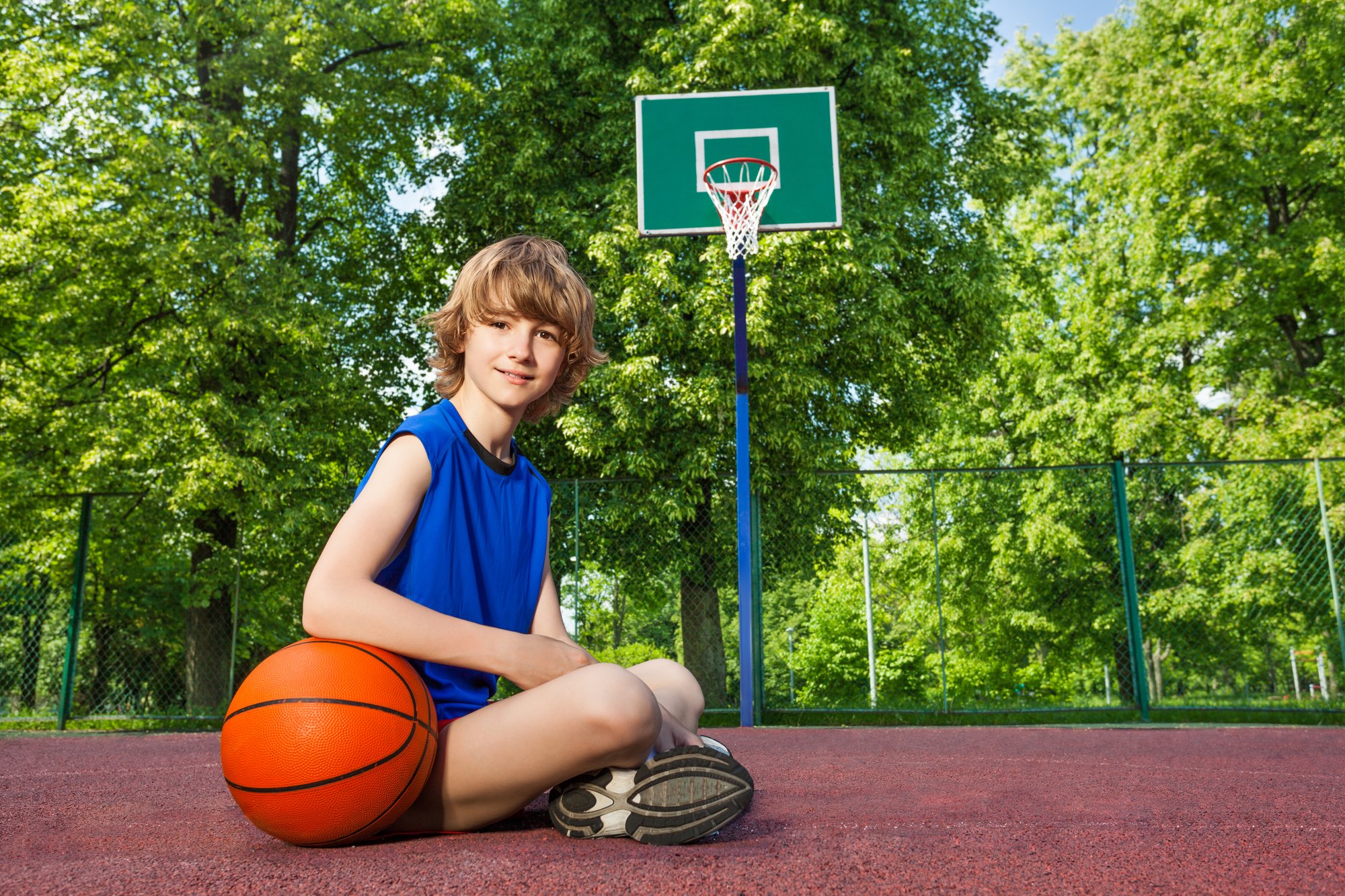 Мальчик на спортивной площадке. Мальчик на спортплощадке. Мальчик с баскетбольным мячом. Мальчик сидит на мяче.